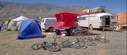 A photograph of our shade, tent, van, and bikes.